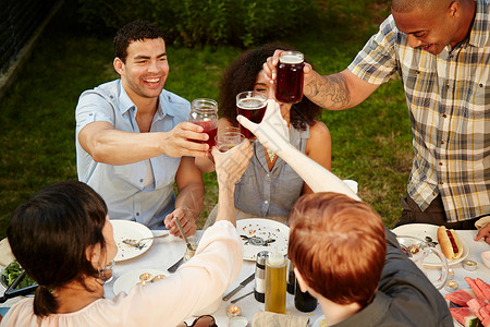 一群朋友在花园派对上喝着饮料团结高清图片素材