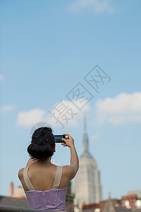 成年妇女拍摄帝国大厦照片图片