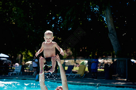 与父亲一起游泳池中玩耍的小孩成年男子高清图片素材