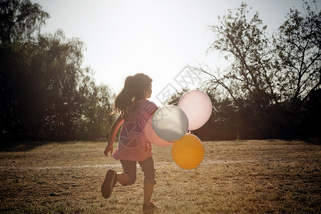 女孩牵着气球奔跑图片