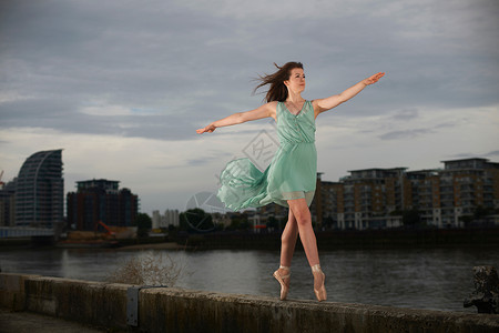 站在河堤上踮起脚尖跳舞的芭蕾舞者图片