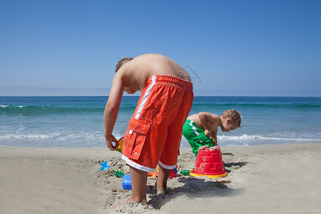 两兄弟在沙滩上玩沙子夏天高清图片素材