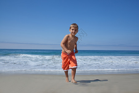 年轻男孩在海滩上奔跑激动高清图片素材