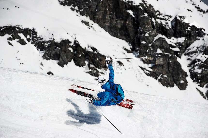 雪山上快速滑雪的滑雪者图片