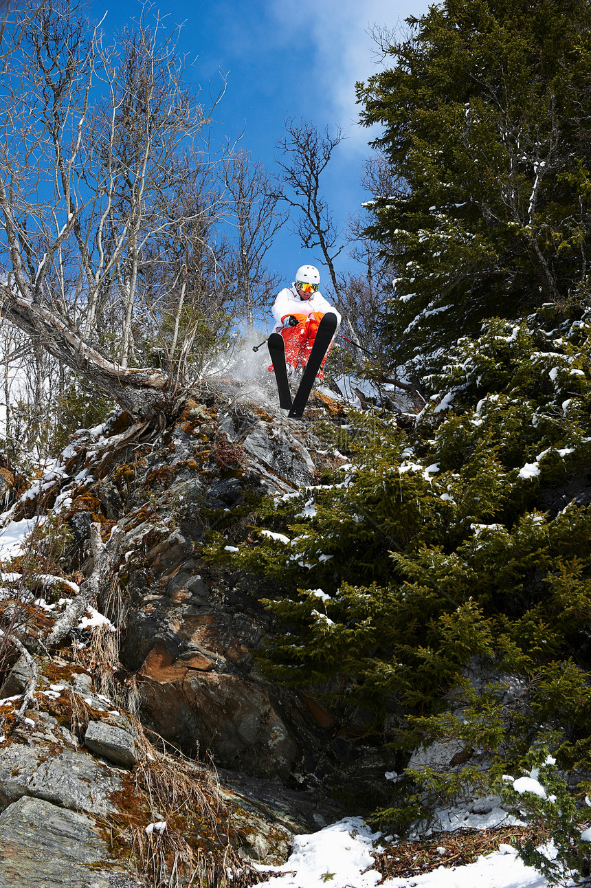 岩石上跳起的滑雪者图片