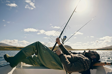 躺在船上钓鱼的男子图片