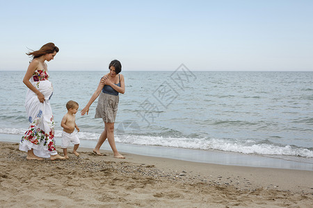妇女和幼儿沿岸行走 图片