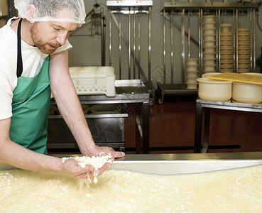 农场工厂里制作一小批咖喱奶酪的工人图片