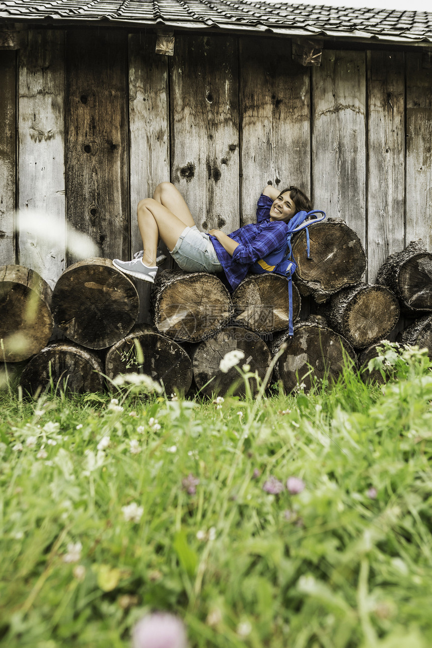 女人躺在一堆原木上图片