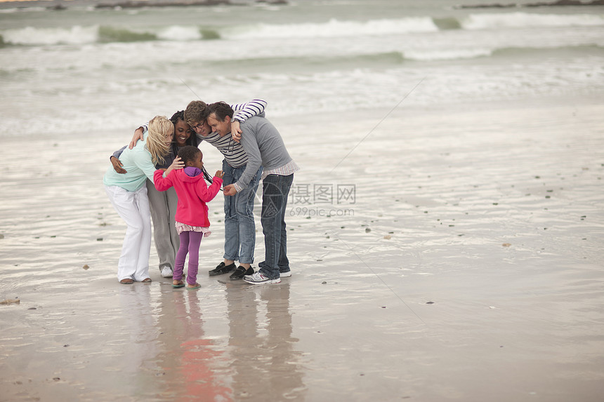 朋友在海滩上与孩子分享秘密图片
