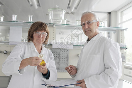 在实验室工作的科学家将黄色液体装在瓶中图片
