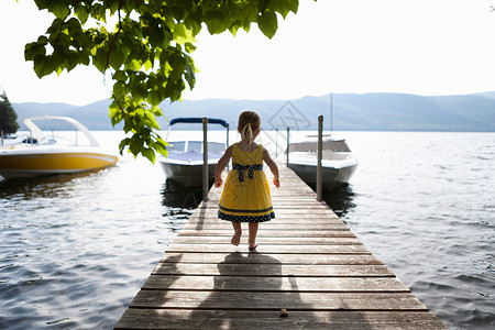 站在湖边码头的小女孩阳光高清图片素材
