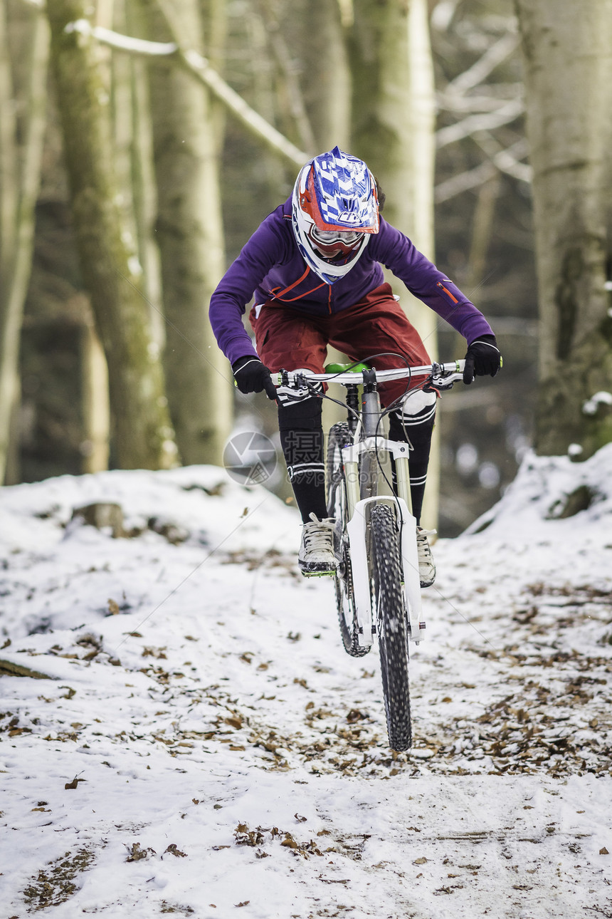 冬季森林中的年轻女子骑自行车图片