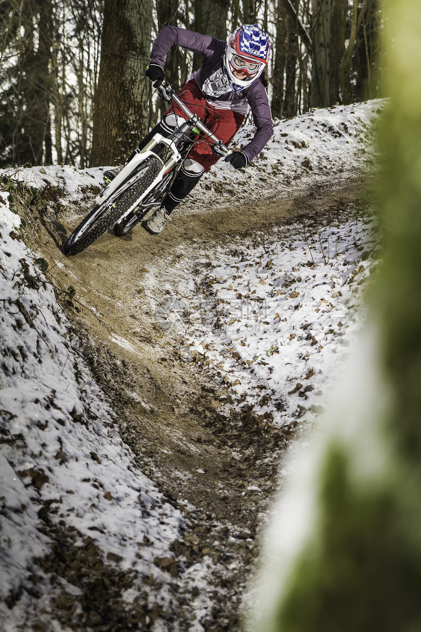 冬季森林里骑自行车的年轻女性图片