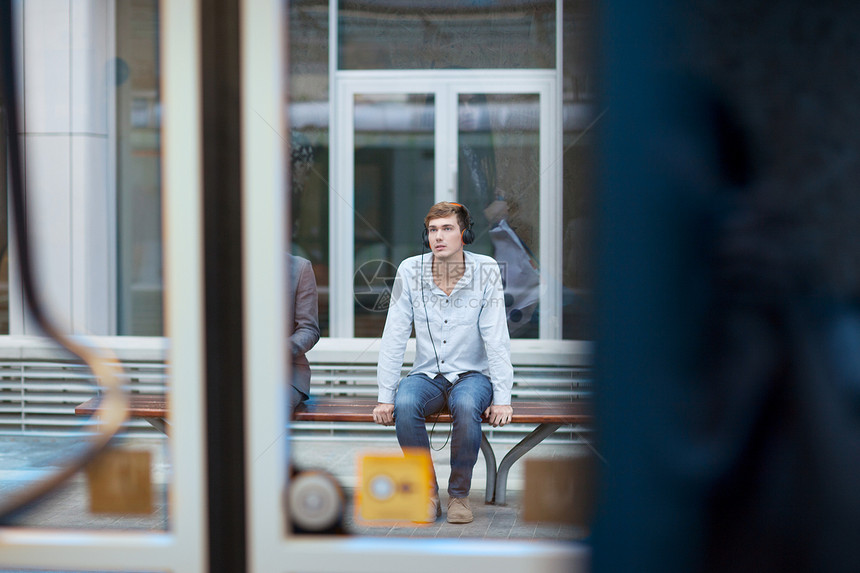 坐在火车站椅上的青年男子图片