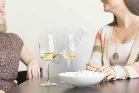 年中成女朋友在桌边喝着葡萄酒和爆米花图片