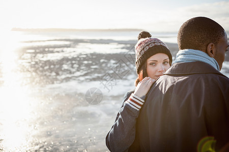 浪漫的年轻夫妇在海滩上行走针织帽高清图片素材