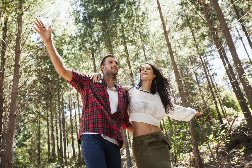 年轻夫妇在森林里伸展手臂图片