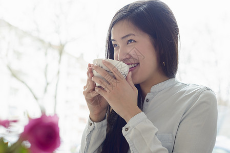 女人笑着喝茶背景图片