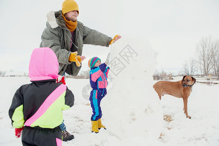 父亲和儿童堆雪人图片