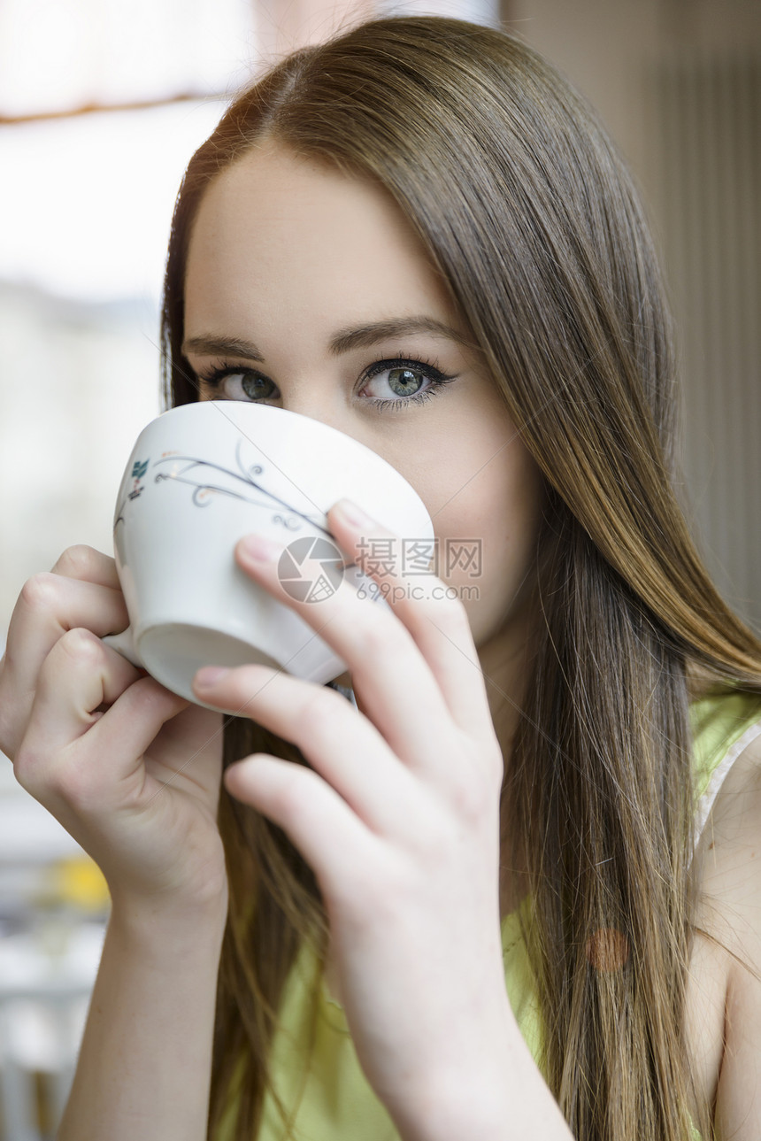 在室内喝咖啡的年轻女子近景肖像图片