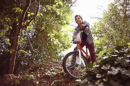 在森林骑自行车的男孩图片