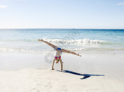 女孩在沙滩上倒立劈叉南非高清图片素材