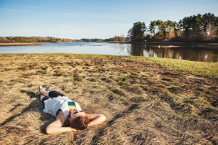 在美国缅因州基特里草地的青年妇女日光浴图片