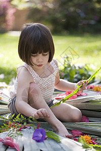 坐在花园里插花的女童图片