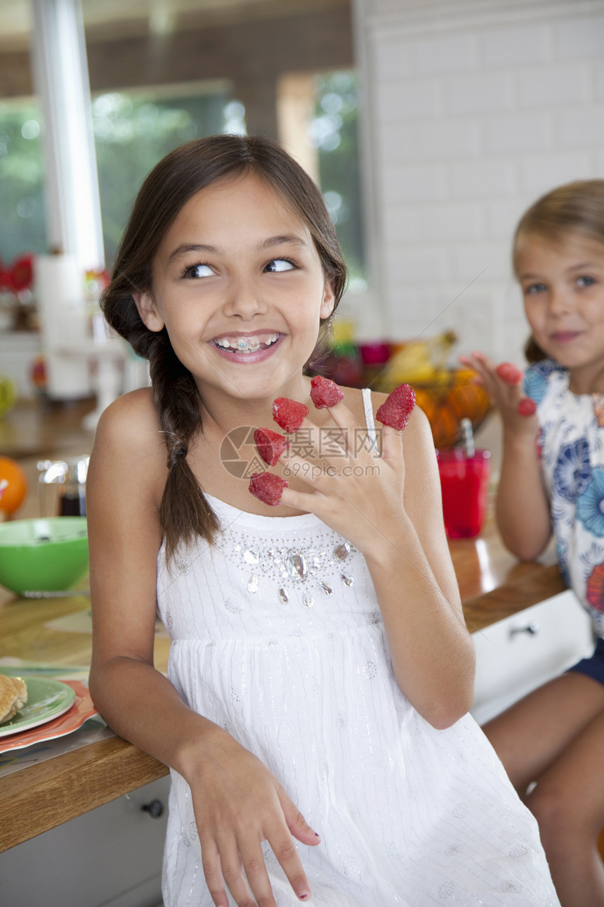 在厨房里手指上沾着草莓的搞怪姐妹图片