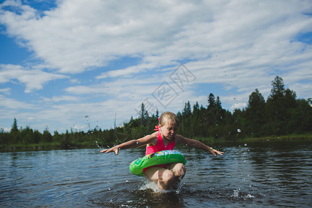 在加拿大安略省印度河的带游泳圈跳起来的少女会游泳者高清图片素材
