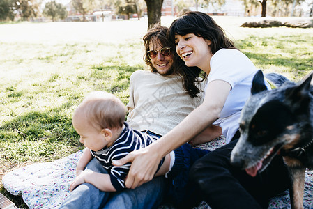 与婴儿一起在公园野餐的年轻夫妇年轻人高清图片素材