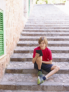 男孩观看数字平板的村级阶梯西班牙马贾卡图片