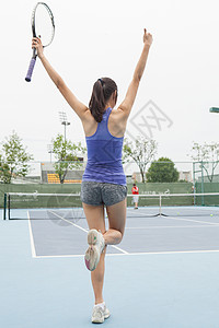 在网球场庆祝的年轻女网球运动员图片