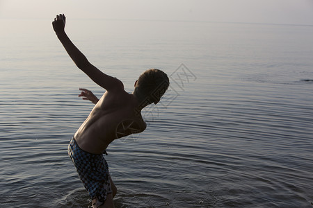 美国密歇根州湖失去平衡的少年男孩假期高清图片素材
