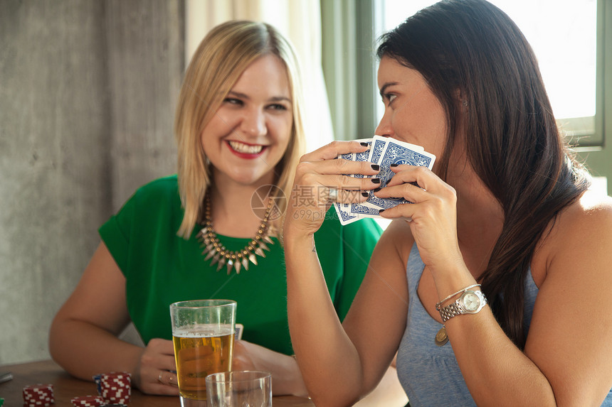 两个女人在桌子上笑着玩牌图片