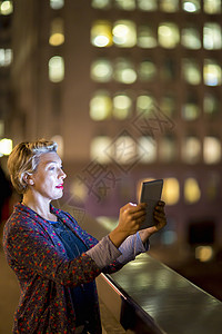 夜晚妇女在看平板电脑
图片