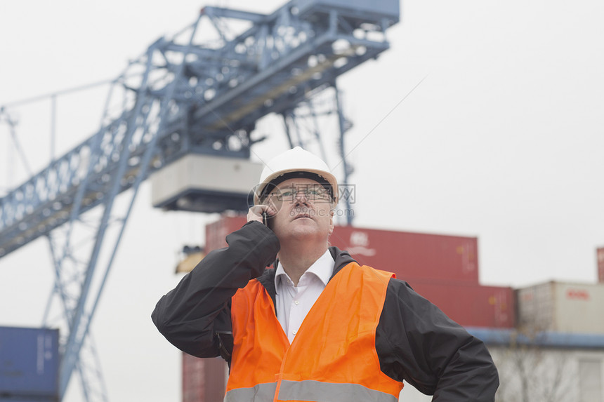 在港口使用智能手机的码头工人图片
