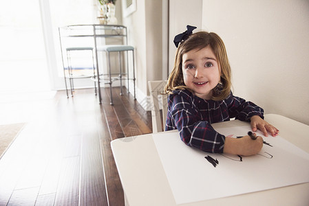 桌边用蜡笔绘画的女孩图片