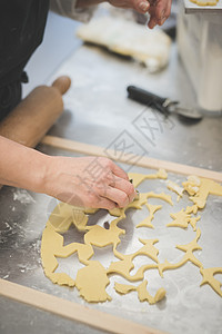 面包师在厨房里用铸模切面团图片