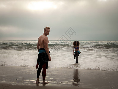 美国加利福尼亚州海滩上等待冲浪女友的帅哥友谊高清图片素材