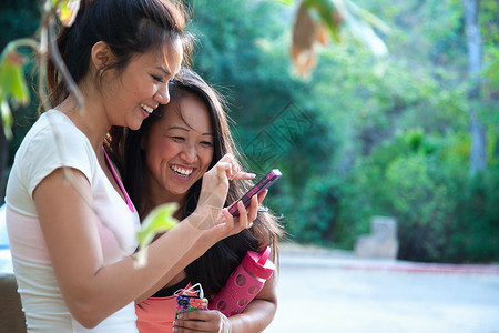两个女人一起在户外看手机图片