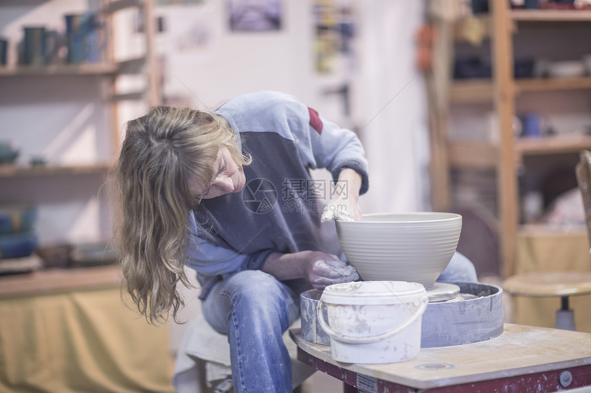 在车间陶器轮上制作陶器女工匠图片