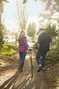 推着自行车行走的年轻夫妇图片