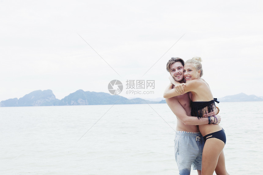 在泰国克拉丹海岸滩拥抱的年轻夫妇图片