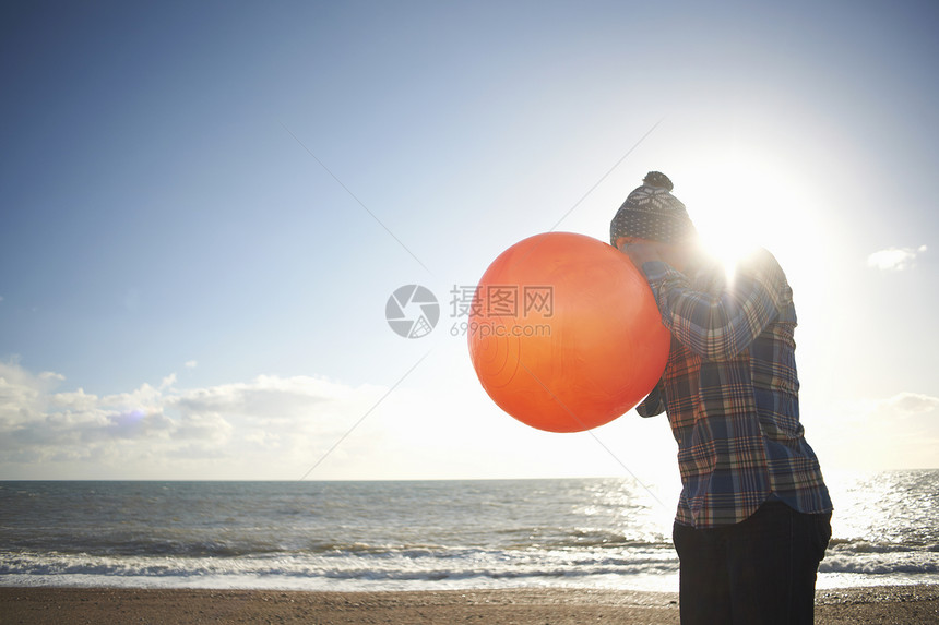 成年男子在海滩上吹气球图片