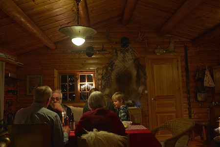 一家人晚上坐在小木屋里吃晚餐图片