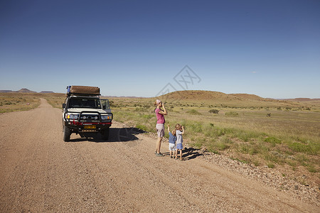 停在路边的车辆母亲和儿子眺望远方高清图片