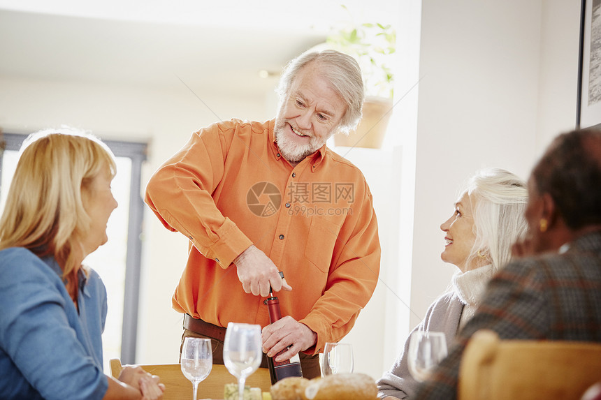 欧美老人为朋友开酒图片