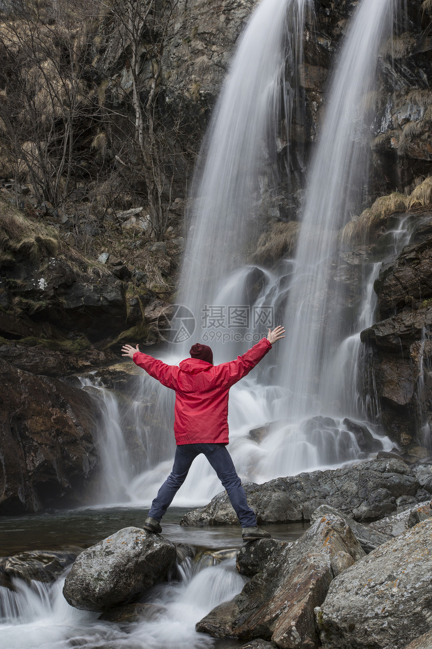 一名男子在意大利皮埃蒙特韦尔巴尼亚普雷莫塞罗托奇河瀑布边拥抱自然图片